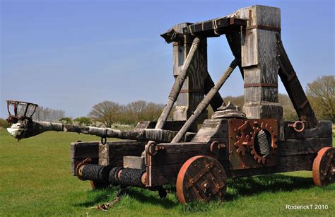 A medieval illustration of a catapult in action